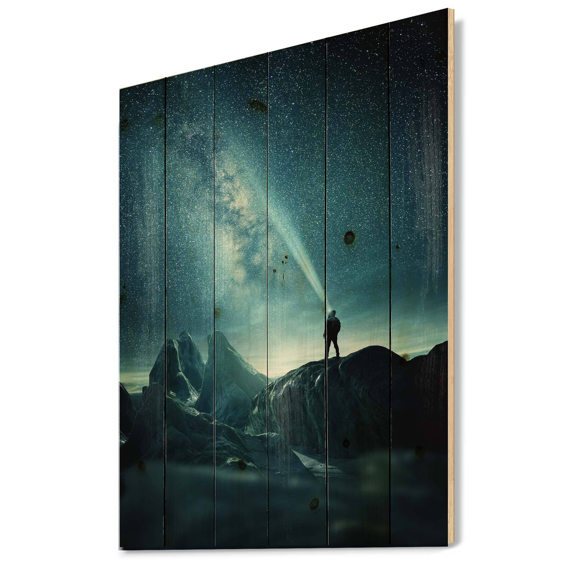 Designart - A Man Shining A Light Into The Night Sky